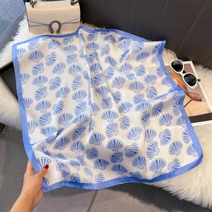 Vue détaillée d'un foulard en soie avec motifs de coquillages bleus sur fond pelucheux