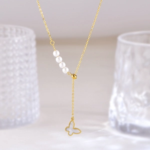 Golden necklace with white shell butterfly pendant and elegant pearl accents on a fine chain