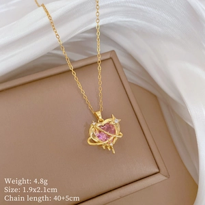 Macro shot of gold necklace with pink heart pendant featuring planet and star details