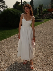 Détail de la robe en coton blanc avec bretelles à nouer et corsage plissé