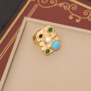 Detailed close-up of a vintage gold ring with pearls and turquoise on a jewelry box
