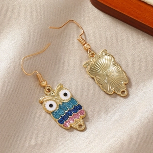 Colorful glitter owl drop earrings with large white eyes on elegant silk fabric