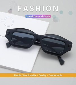 Detail view of black geometric polygon sunglasses on a minimalist white book display