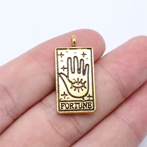 Detailed close-up of golden tarot fortune pendant with mystical palm and eye motif