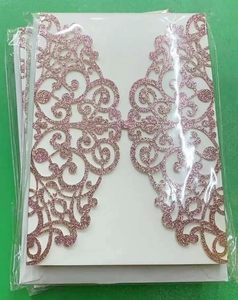Detail of rose gold glitter laser-cut invitation cover with intricate hollow design