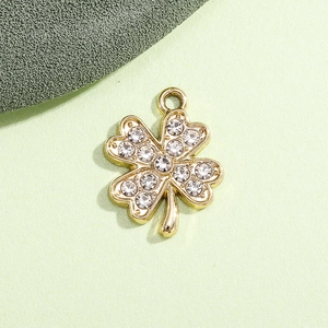 Macro shot of gold-plated clover pendant with sparkling rhinestones and open ring
