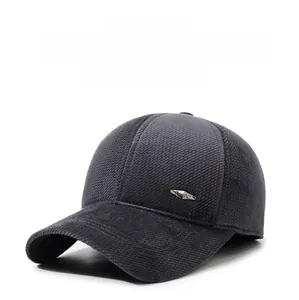 Dettaglio del cappello grigio in tessuto spesso con logo metallico decorativo