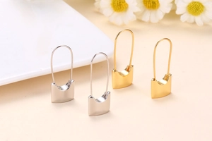 Detail of 18k gold and silver plated safety pin earrings with U-shaped long hooks