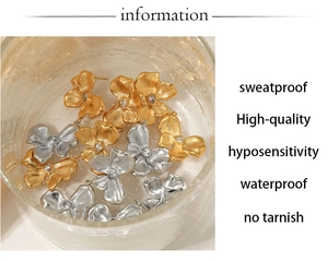 Detailed view of flower-shaped stud earrings in gold and silver with zircon accents