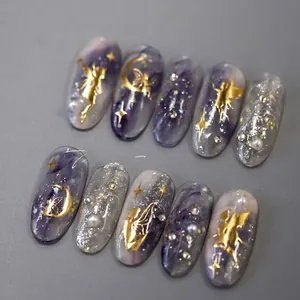 Detail of dreamlike purple marble press-on nails with gold fairy relief and pearls