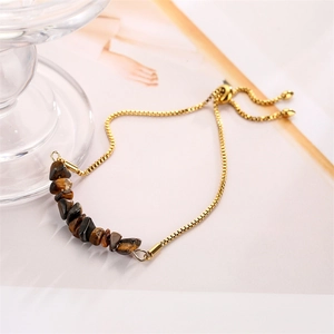 Macro detail of tiger eye stone beads with golden adjustable slider clasp on chain bracelet