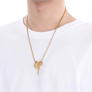 Close-up of golden snake pendant necklace featuring intricate scales on a male model