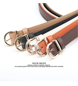 Detail of five slim faux leather belts with polished gold D-shape buckles in various colors