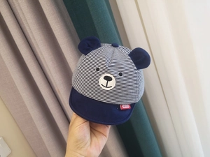 Close-up of navy blue striped baby sun hat with cute 3D bear ears and soft fabric texture