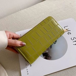 Close-up of lime green crocodile embossed long wallet with gold zipper detail