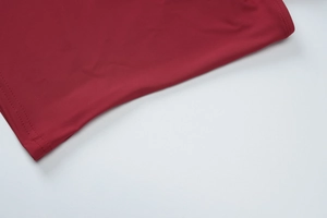 Gros plan détaillé d'un tissu extensible rouge montrant des coutures précises et une texture