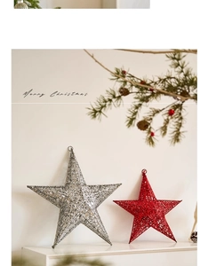 Close-up of silver sequined and red hollow-out star ornaments on a white festive mantle