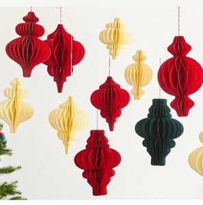 Detail of hanging honeycomb paper Christmas tree lanterns in red, cream, and green colors