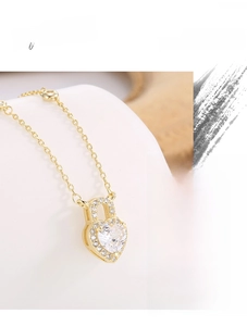 Macro detail of gold plated S925 silver heart lock necklace with sparkling zircons