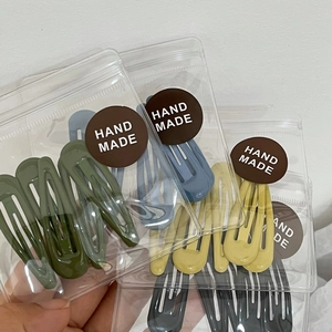 Detail of colorful drip oil water drop hair clips in clear handmade packaging bags