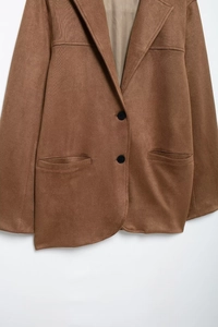 Detail of brown faux suede blazer with double-breasted buttons and front pockets