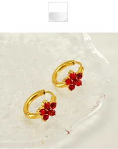 Détail de boucles d'oreilles flocon de neige en or 18 carats et zircons rouges