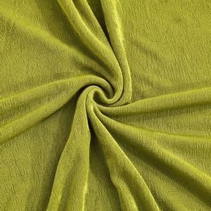 Détail macro du tissu côtelé vert citron avec reflets doux et drapé élégant de la robe