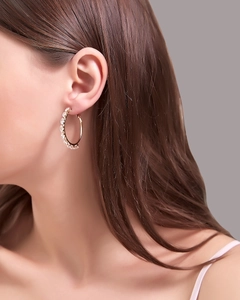 Close-up of rose gold plated hoop earring with sparkling pavé zircons on a model