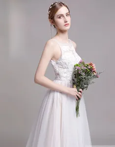 Détail de la broderie en dentelle blanche et du décolleté en tulle sur la robe de mariée