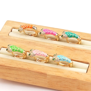 Detail of colorful enamel snake earrings with sparkling cubic zirconia on a wooden display