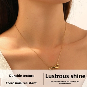 Close-up of gold infinity symbol pendant necklace worn on a model's neck