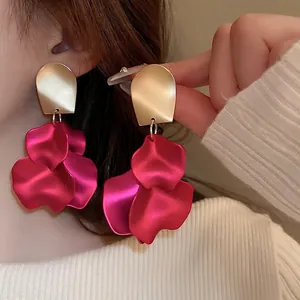 Long rose red petal tassel earrings with matte gold water drop stud on a model