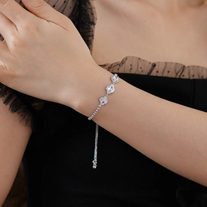 Close-up of a silver adjustable flower bracelet with oval zircons on a model arm