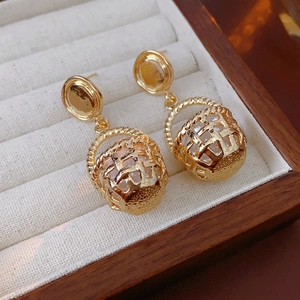 Vintage gold basket earrings with faux pearls on velvet tray, elegant jewelry design