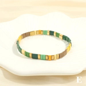Detail shot of colorful Tila bead stretch bracelet on a white floral ceramic tray