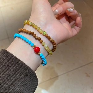 Vue détaillée d'un ensemble de trois bracelets en perles de turquoise et bois au poignet