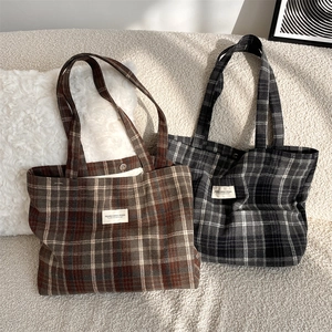 Detail of plaid canvas tote bags with magnetic closure and soft textured fabric