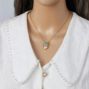 Titanium steel necklace with golden crown pendant and pink heart gemstone on a model