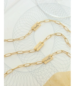Primo piano del bracciale placcato oro 18K con ciondoli rettangolari Lucky su superficie