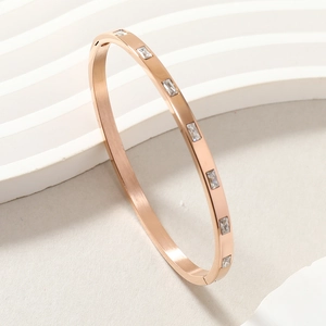 Minimalist rose gold stainless steel bangle featuring inset rectangular white zircons