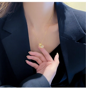 Detail of opening golden seashell pendant with pearl and zircon inlay on a model