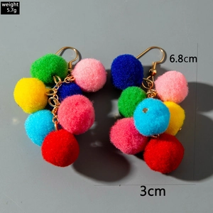 Detail view of colorful knit pom-pom earrings with gold hooks, size 6.8cm and weight 5.7g