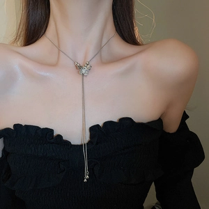 Detail of silver butterfly pendant with dangling tassel chains on a neck model