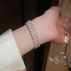 Close-up of a multi-layer pearl bracelet with diamonds on a woman's wrist
