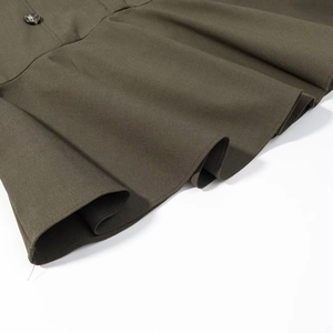 Detail of olive green dress showing thick twill fabric texture and tortoise shell button