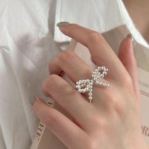 Minimalist 925 sterling silver beaded bow ring shown on model for a trendy look