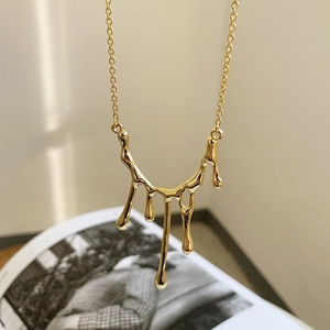 Close-up of golden liquid lava pendant necklace with unique melting metal texture