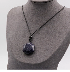 Detailed shot of the blue goldstone hexagonal star pendant on a grey jewelry display