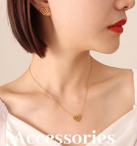 Close-up of model wearing gold-plated heart bead necklace and matching stud earrings set