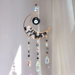 Golden moon suncatcher with black crystals and evil eye beads creating rainbow light
